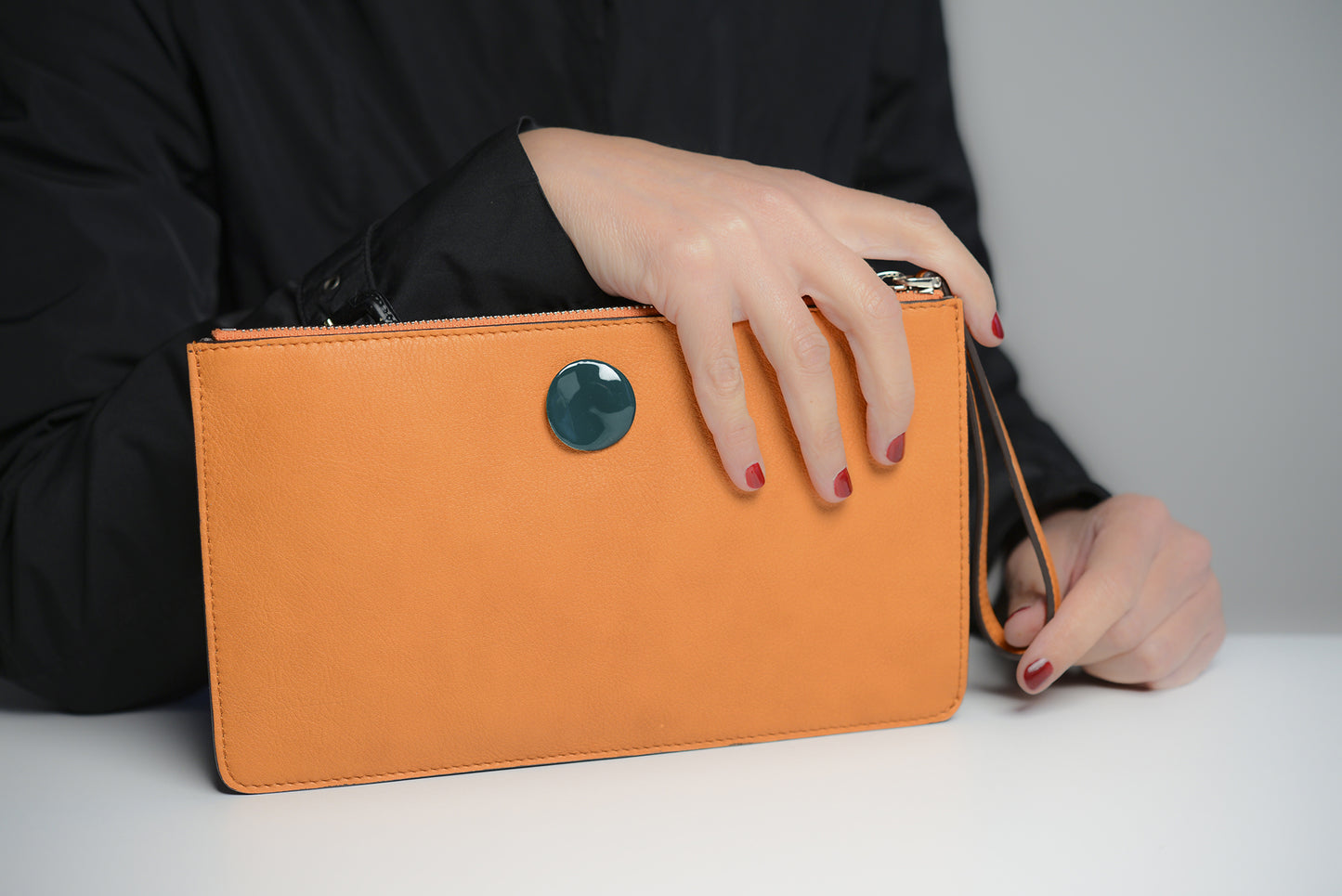 Pochette in pelle arancione con dettaglio in argento smaltato